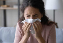 Rising Chronic Epidemic: Are You in Danger? Woman sneezing into a tissue indoors