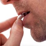 Close up of a man preparing to take a pill