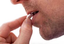 Hair Loss Pill Sparks Suicide Controversy Close up of a man preparing to take a pill