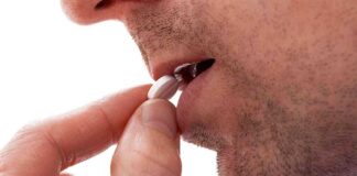 Close up of a man preparing to take a pill