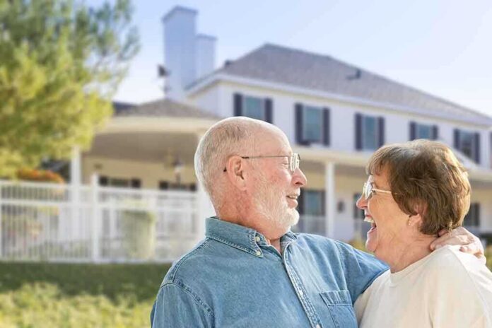 shutterstock_229063660.jpg Elderly couple smiling and enjoying each others company in front of a house
